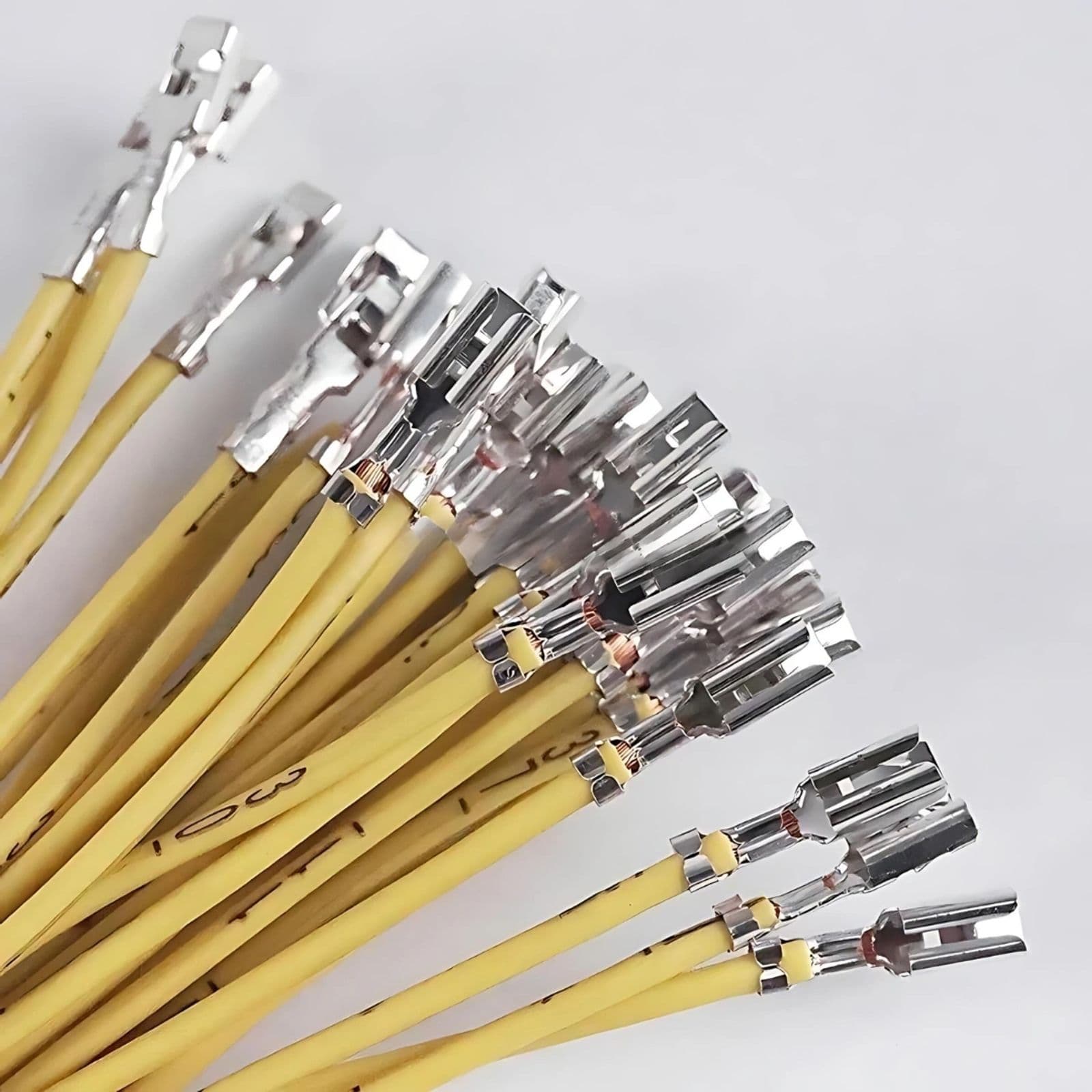 A bundle of yellow electrical wires with crimped spade terminals for a custom wire assembly.